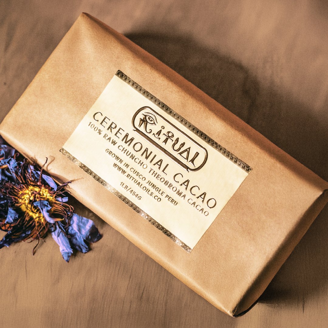 Ritual Oils ceremonial cacao block in paper wrap with blue lotus petals